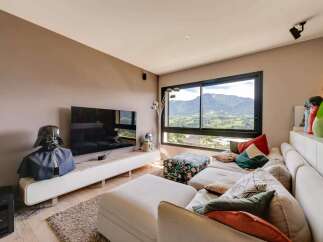 Luxury mountain view living room with modern sectional sofa and large screen TV.