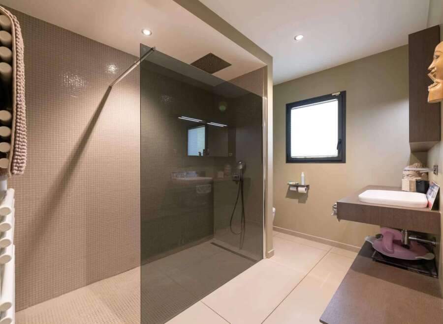 This stunning bathroom boasts a walk-in shower with a sleek glass enclosure and modern fixtures.