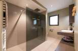 This stunning bathroom boasts a walk-in shower with a sleek glass enclosure and modern fixtures.