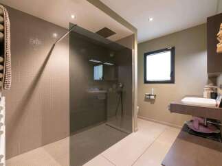 This stunning bathroom boasts a walk-in shower with a sleek glass enclosure and modern fixtures.