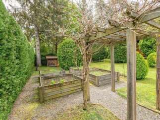 This charming property boasts a serene garden with raised wooden planters, perfect for cultivating your favorite herbs and vegetables.