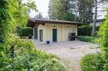 Charming detached garage nestled in a lush green landscape, offering ample storage space and a tranquil setting.