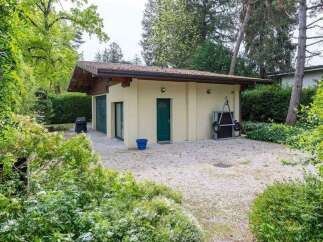 Charming detached garage nestled in a lush green landscape, offering ample storage space and a tranquil setting.
