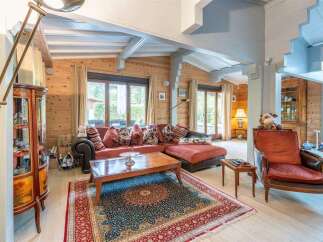 This stunning chalet boasts a spacious living area with large windows offering abundant natural light and views of the surrounding landscape.