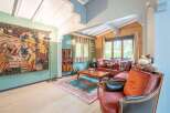 This stunning property boasts a spacious living area with high ceilings and large windows, offering ample natural light.