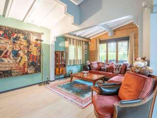 This stunning property boasts a spacious living area with high ceilings and large windows, offering ample natural light.
