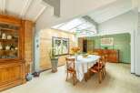 This stunning property boasts a bright and airy dining area with a vaulted ceiling and skylights, creating a naturally lit space.