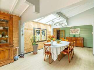 This stunning property boasts a bright and airy dining area with a vaulted ceiling and skylights, creating a naturally lit space.