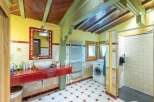 Charming bathroom with rustic wooden ceilings and red accents.