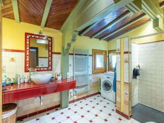 Charming bathroom with rustic wooden ceilings and red accents.