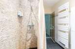 Modern bathroom with a walk-in shower, stylish mosaic tile, and a heated towel rack.