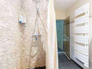 Modern bathroom with a walk-in shower, stylish mosaic tile, and a heated towel rack.