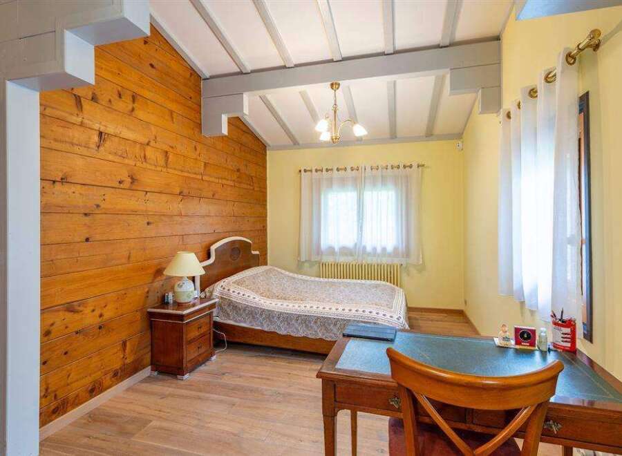 Charming bedroom with wood-paneled walls and a cozy atmosphere.
