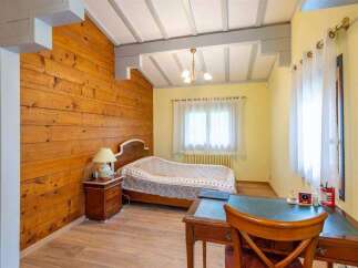 Charming bedroom with wood-paneled walls and a cozy atmosphere.