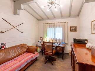 Charming study with wooden floors and beamed ceiling.