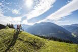 Couple enjoying a scenic mountain bike ride with breathtaking views of the Alps.