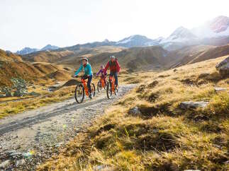 Family of four enjoys an e-bike adventure through stunning alpine scenery.