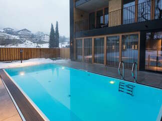 Luxury hotel with outdoor heated pool, perfect for a relaxing winter getaway.