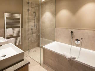 This luxurious bathroom boasts a spacious bathtub and a separate walk-in shower, perfect for relaxation and rejuvenation.