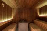 Indulge in tranquility within this exquisitely designed sauna, showcasing rich, dark wood paneling and ambient lighting.