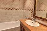 Charming bathroom with rustic wooden vanity and a bathtub.