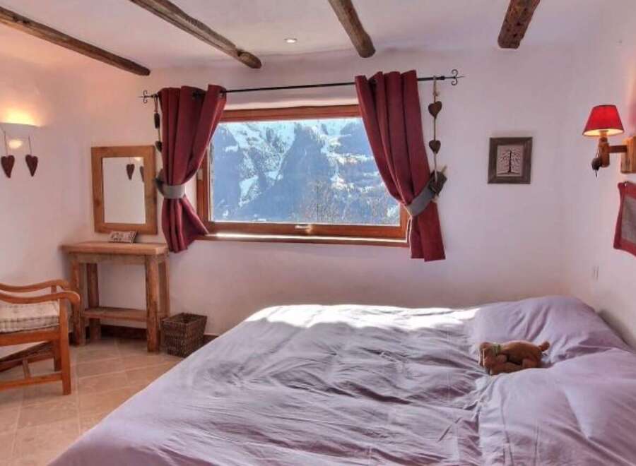 Cozy chalet bedroom with stunning mountain views.