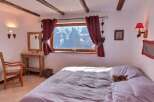 Cozy chalet bedroom with stunning mountain views.