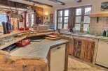 Rustic mountain kitchen with exposed beams, granite countertops, and custom wooden cabinetry.