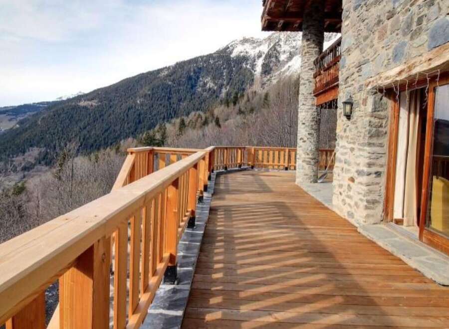 Mountain view chalet with a spacious wooden deck perfect for enjoying the stunning scenery.