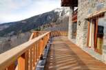 Mountain view chalet with a spacious wooden deck perfect for enjoying the stunning scenery.