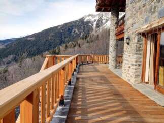 Mountain view chalet with a spacious wooden deck perfect for enjoying the stunning scenery.