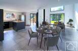 This stunning open-plan property boasts a modern kitchen, spacious dining area, and a relaxing living room with large windows offering ample natural light and views of the garden.