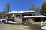 This charming chalet-style home boasts a spacious garage, perfect for storing skis and outdoor gear.
