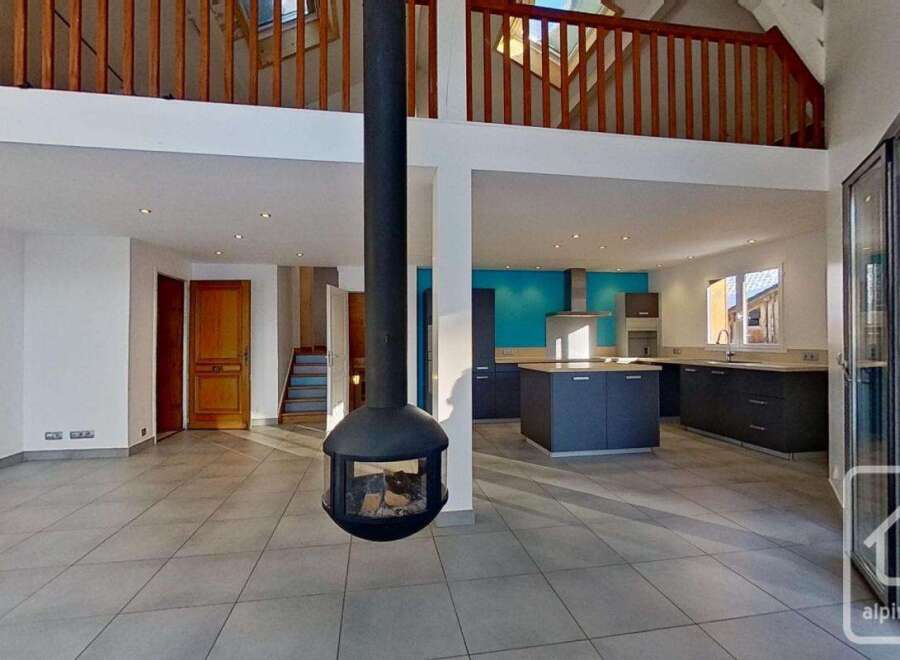 This stunning open-plan property boasts a contemporary kitchen with sleek dark grey cabinetry and a vibrant turquoise feature wall.