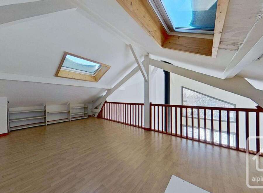 This attic conversion boasts a spacious open-plan layout with ample natural light from multiple skylights.