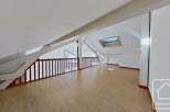 This attic conversion boasts a spacious open-plan layout with light wood flooring, offering versatile living space.