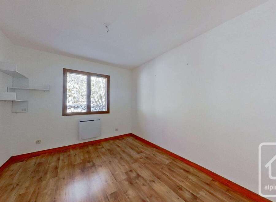 This bright and airy bedroom features light wood flooring, creating a warm and inviting atmosphere.