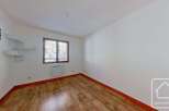 This bright and airy bedroom features light wood flooring, creating a warm and inviting atmosphere.