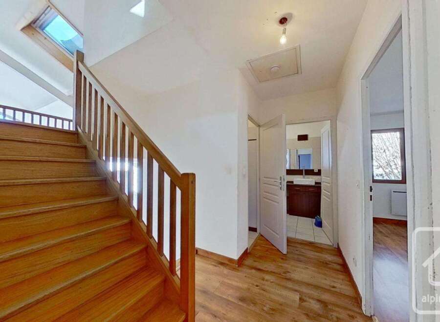 This stunning property boasts a beautiful wooden staircase leading to an upper level, complete with a spacious hallway and access to a modern bathroom.