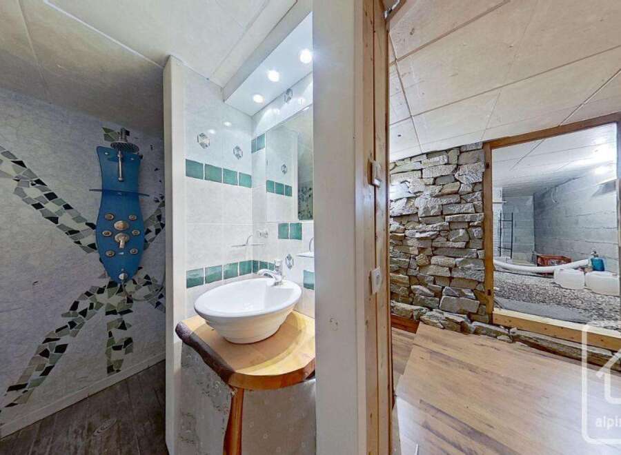 Unique bathroom with a mosaic-tiled shower and a rustic wooden sink vanity.