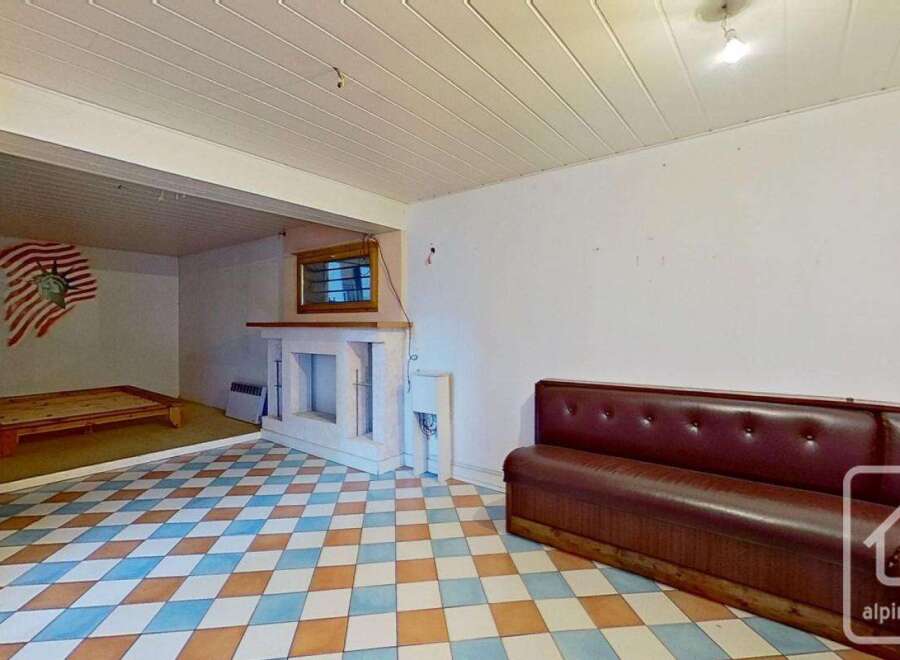 This spacious room boasts a unique diamond-patterned tile floor and a built-in fireplace, perfect for cozy evenings.
