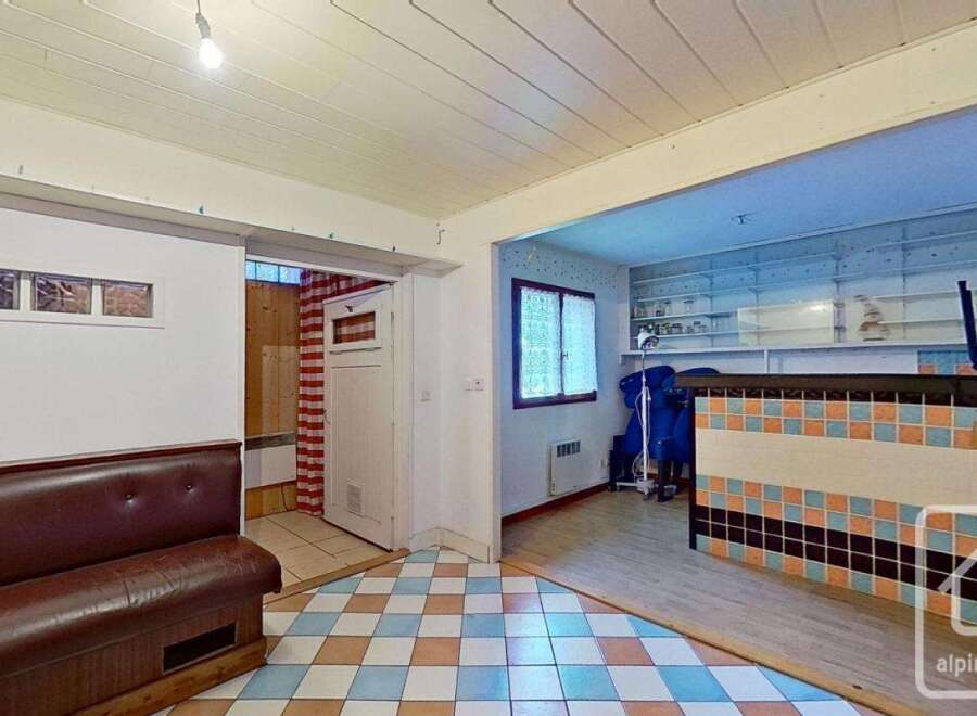 This charming property boasts a unique retro-style kitchen with a tiled counter and built-in shelving, perfect for a cozy atmosphere.