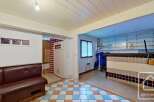 This charming property boasts a unique retro-style kitchen with a tiled counter and built-in shelving, perfect for a cozy atmosphere.