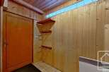 This charming property boasts a spacious entrance hall with wooden wall paneling and built-in shelving, perfect for storage.