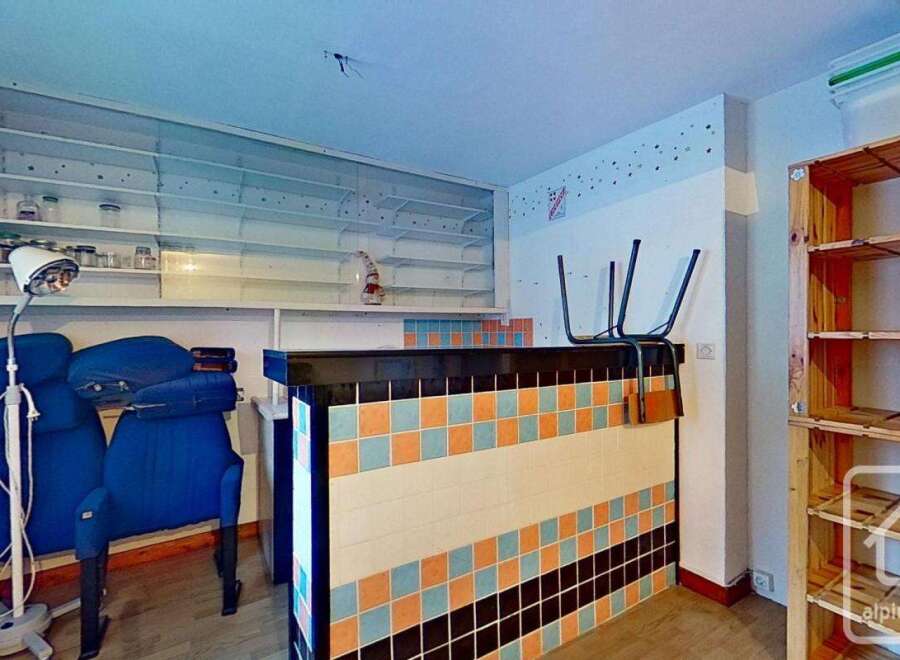 This charming property boasts a unique interior with built-in shelving, a retro-tiled counter, and ample storage solutions.