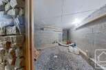 Discover this spacious cellar, perfect for storage or wine-making, featuring a gravel floor and sturdy block walls.
