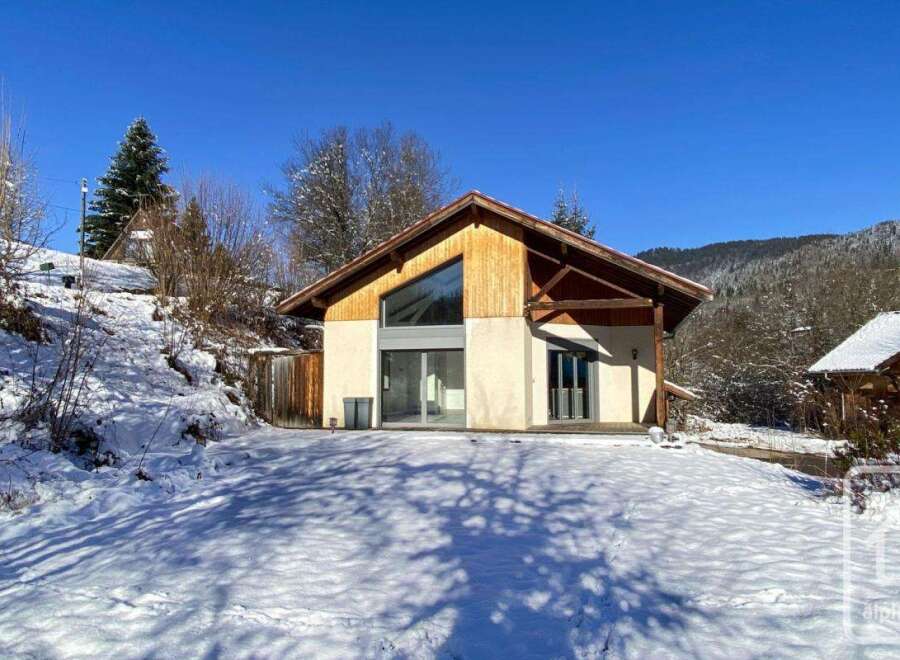 This stunning chalet boasts a modern design with large windows offering breathtaking mountain views.