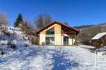 This stunning chalet boasts a modern design with large windows offering breathtaking mountain views.