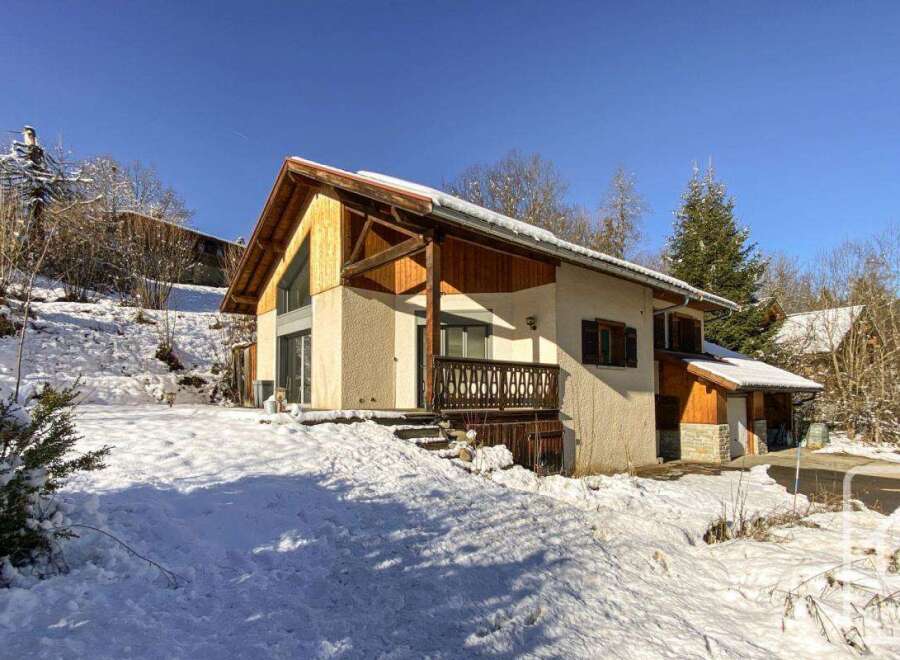 This charming chalet boasts a stunning mountain view and is nestled in a picturesque snowy landscape.
