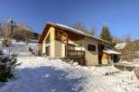 This charming chalet boasts a stunning mountain view and is nestled in a picturesque snowy landscape.